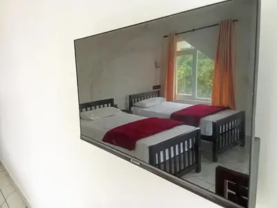 two beds in a mirror on a wall at Appu's Nido in Pallipuram
