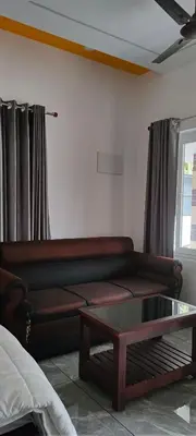 a living room with a couch and a coffee table at Coastal Den Homestay in Pallipuram