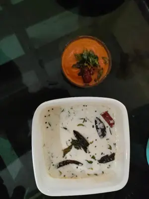 a bowl of soup and a bowl of food on a table at Coastal Den Homestay in Pallipuram