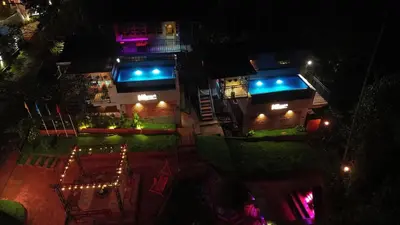 a building with blue lights on it at night at Mannath Private Pool Villas at Vellarimala in Wayanad