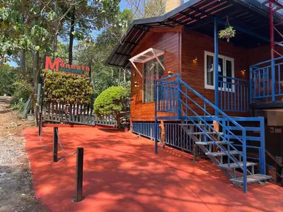 a wooden cabin with a staircase leading up to it at Mannath Private Pool Villas at Vellarimala in Wayanad