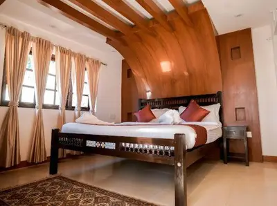 a bedroom with a large bed with a wooden ceiling at Lakefront Home Hotel in Ooty