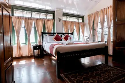 a bedroom with a bed with a teddy bear on it at Lakefront Home Hotel in Ooty