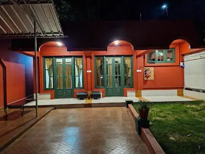 a house with orange walls and green doors at Lakefront Home Hotel in Ooty