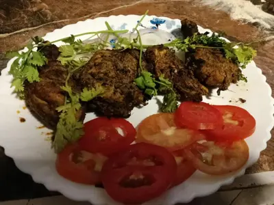 a plate of food with meat and tomatoes on it at IInfinity Kodaikanal in Kūkkāl