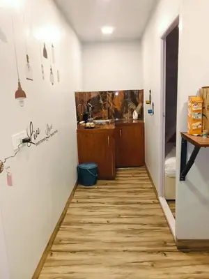 a hallway with a kitchen and a wooden floor at IInfinity Kodaikanal in Kūkkāl