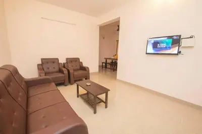 a living room with a couch and chairs and a tv at ThulasiRams Service Apartments in Coimbatore