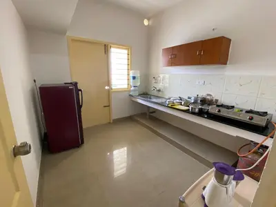 a kitchen with a refrigerator and a counter top at ThulasiRams Service Apartments in Coimbatore