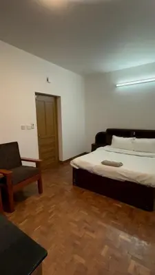 a bedroom with a bed and a chair in it at Amarah Homestay in Ooty
