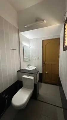 a bathroom with a white toilet and a sink at Amarah Homestay in Ooty