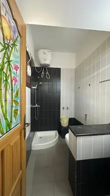 a bathroom with a tub and a toilet and a sink at Amarah Homestay in Ooty
