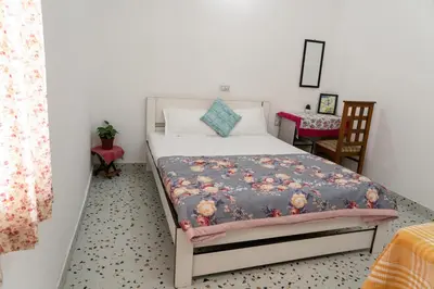a bedroom with a bed in a room with a chair at Maya Homez - Coimbatore in Coimbatore