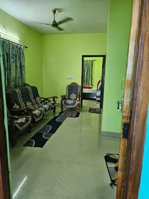 a living room with two chairs and a mirror at Pavithra cottage munnar in Munnar
