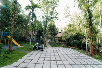 a scooter parked in a park with a playground at Le Vista Resort in Sultan Bathery