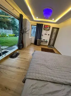 a bedroom with a large bed and a large window at Serene Hills in Ooty