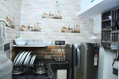 a kitchen with a stainless steel refrigerator and a brick wall at Serene Hills in Ooty