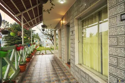 a building with a walkway with potted plants on it at Serene Hills in Ooty