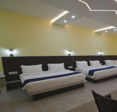 two beds in a hotel room with two bedsvisor at Coastal Grand Resorts - Akshaya in Kotagiri