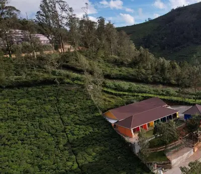 an aerial view of a house in a field at Coastal Grand Resorts - Akshaya in Kotagiri