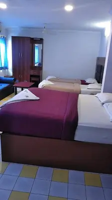 two large beds in a room with at Asoka Inn in Mettuppālaiyam