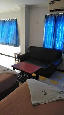a living room with a couch and a table at Asoka Inn in Mettuppālaiyam
