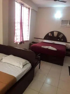 a small bedroom with a bed and a couch at Asoka Inn in Mettuppālaiyam