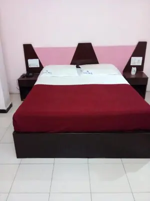 a bed in a room with two nightstands and sidx sidx sidx at Asoka Inn in Mettuppālaiyam