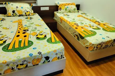 two beds with cartoon animals on them in a bedroom at Home stay - Near Cochin Airport in Angamali