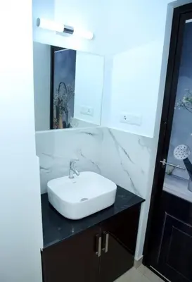 a bathroom with a white sink and a mirror at Home stay - Near Cochin Airport in Angamali