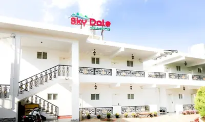 a white building with a sign that reads stay date at Treebo Skydale Inn & Suites With Mountain View in Ooty