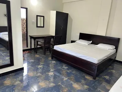 a bedroom with a bed and a table with chairs at Arulmozhi Dream in Ooty