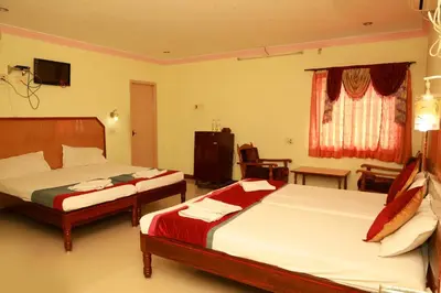 a hotel room with two beds and a television at KG Grand Inn in Erode