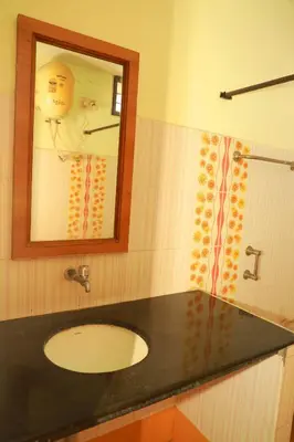 a bathroom with a sink and a mirror and a shower at KG Grand Inn in Erode
