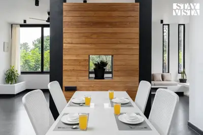 a dining room with a white table and white chairs at StayVista at Lotus Lumiere with Breakfast & jacuzzi in Madikeri