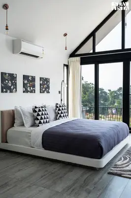 a bedroom with a large bed and a large window at StayVista at Lotus Lumiere with Breakfast & jacuzzi in Madikeri
