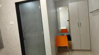 a door in a room with a orange chair at Arasan Residency in Kotagiri