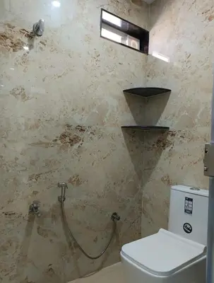 a bathroom with a toilet and a shower at Arasan Residency in Kotagiri