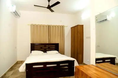 a bedroom with a bed and a ceiling fan at Shoreline in Kozhikode