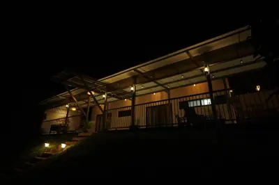 a building with lights on the front at night at Nila Paithal in Paithalmala