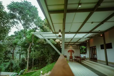 a porch of a house with trees in the background at Nila Paithal in Paithalmala