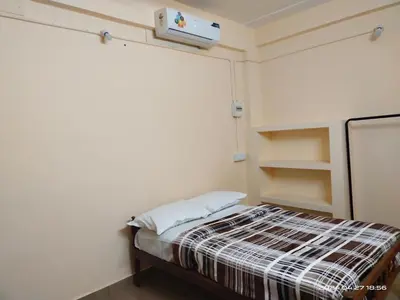 a small room with a bed and a projector at Rest House @ Merlys Fruit Garden in Thattakād