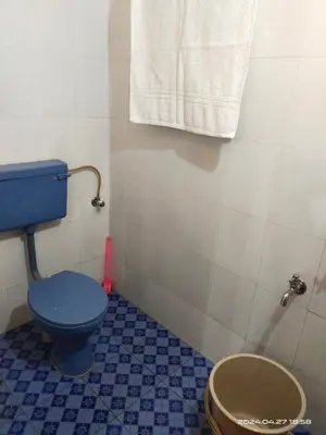 a bathroom with a blue toilet and a towel at Rest House @ Merlys Fruit Garden in Thattakād