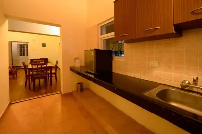 a kitchen with a sink and a kitchen with a table at Sabol Holidays in Ooty