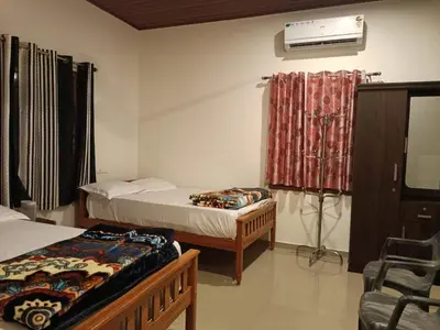 a room with two beds and a air conditioner at The Serene Cottage in Viripara