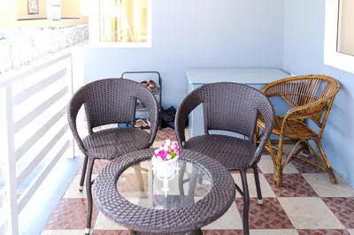 three rattan chairs and a glass table on a porch at The Jade Highlands Mountain View 2 bhk Villa in Kodaikānāl