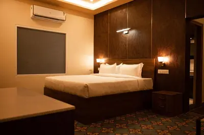 a hotel room with a bed in a room at Poojaris Nirantara - Mysuru in Hampāpura
