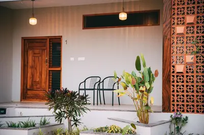 a porch with two chairs and a table with plants at Poojaris Nirantara - Mysuru in Hampāpura