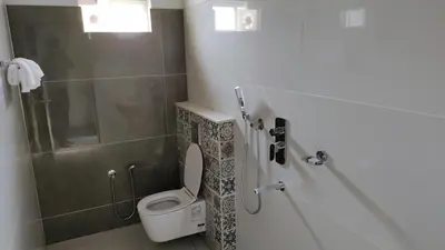 a bathroom with a toilet and a shower at Mist View Resort Wayanad in Wayanad