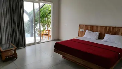 a bedroom with a bed and a sliding glass door at Mist View Resort Wayanad in Wayanad