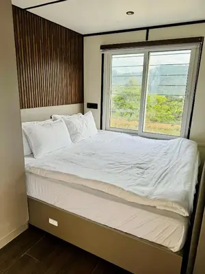 a large bed in a room with a window at The Jade Highlands Mountain View Container Studio Room in Kodaikānāl